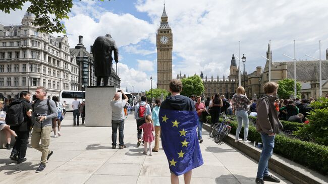 Мужчина с Мужчина с флагом ЕС на Парламентской площади Лондона, Великобритания. Архивное фотоЕС на Парламентской площади Лондона, Великобритания. 25 июня 2016