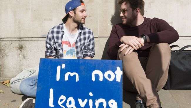 Молодые люди с плакатом у здания парламента в Лондоне после референдума по сохранению членства Великобритании в Европейском Союзе. Архивное фото