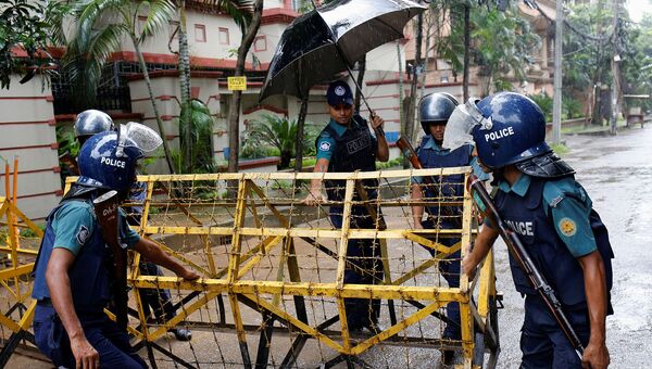 Сотрудники полиции Бангладеша устанавливают ограждение на месте теракта в городе Дакка