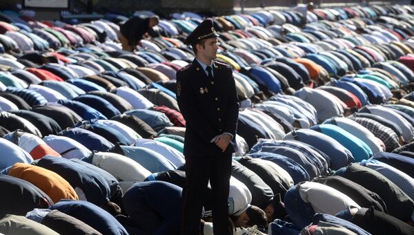 Сотрудник правоохранительных органов перед намазом в день праздника Ураза-байрам у Соборной мечети в Москве