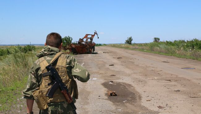 Военнослужащие Народной милиции ЛНР на фоне разбитой техники украинских силовиков под Дебальцево  в Донбассе. Архивное фото