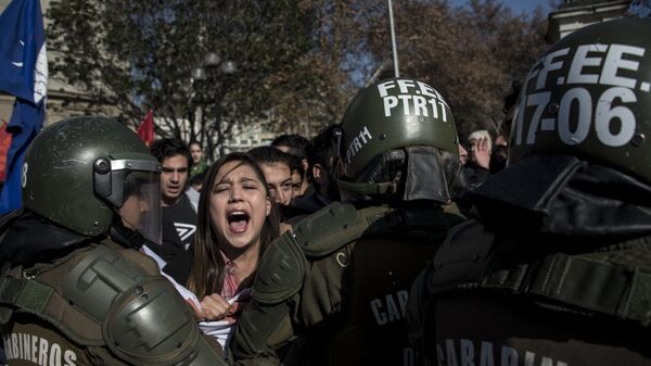 Полиция задерживает людей во время несанкционированного протеста студентов против реформы правительства в области образования, Сантьяго, Чили
