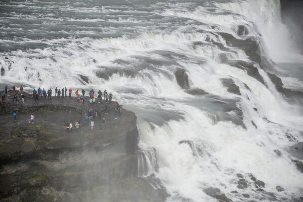 Посетители у водопада Гюдльфосс в Исландии