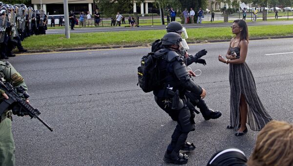 Полицейские задерживают участницу акции протеста в связи с убийством афроамериканца в городе Батон-Руж в штате Луизиана
