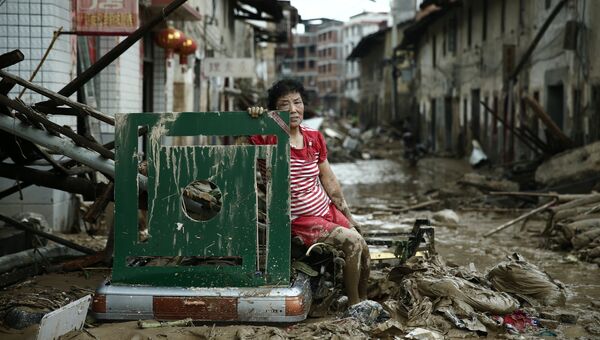 Женщина сидит на руинах после тайфуна Непартак в Китае. 10 июля 2016