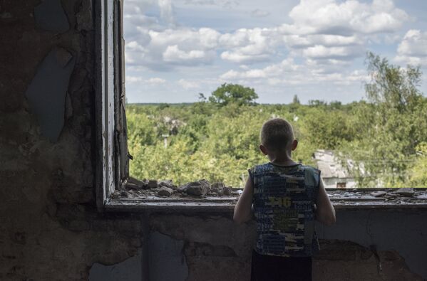 Подросток у окна в разрушенном спортивном зале средней школы поселка Шахты 6/7 близ Горловки
