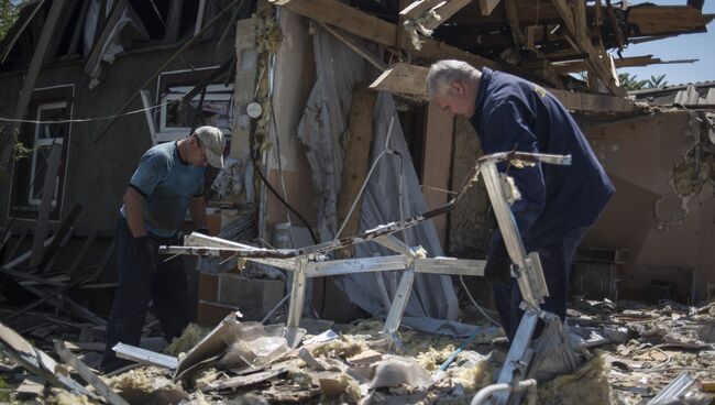 Мужчины у разрушенного дома после ночного обстрела. Архивное фото