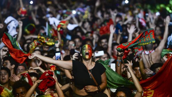 Болельщики футбольной команды Португалии празднуют победу своей команды на Дворцовой площади в Лиссабоне