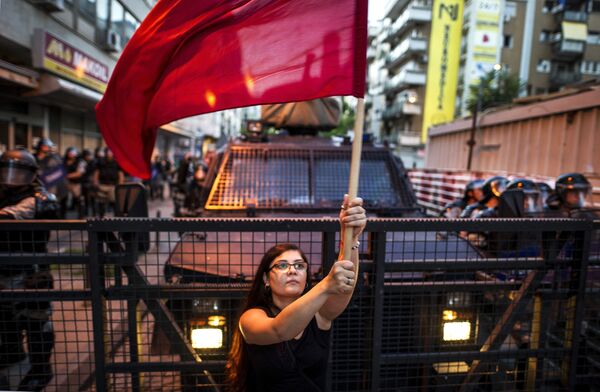 Женщина машет красным флагом во время антиправительственной акции в Скопье. 11 июля 2016 года