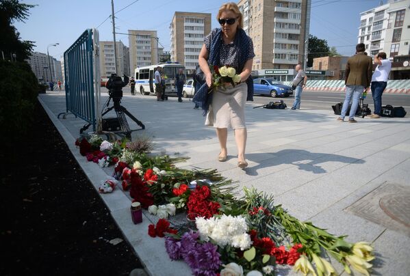Женщина возлагает цветы у посольства Франции в Москве в память о погибших в результате террористических акта в Ницце