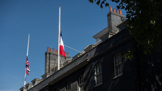 Флаги Великобритании и Франции наполовину приспущены над резиденцией британского премьер-министра на Даунинг-стрит в связи с терактом в Ницце, 15 июля 2016