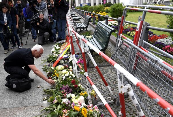 Человек оставляет цветы перед посольством Франции в Берлине. 15 июля 2016 года