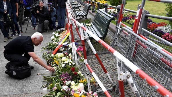 Человек оставляет цветы перед посольством Франции. Архивное фото