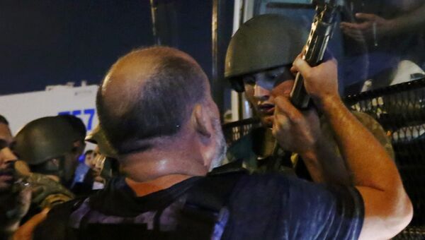 Солдат отдает оружие полицейскому на площади Таксим в Стамбуле. 16 июля 2016