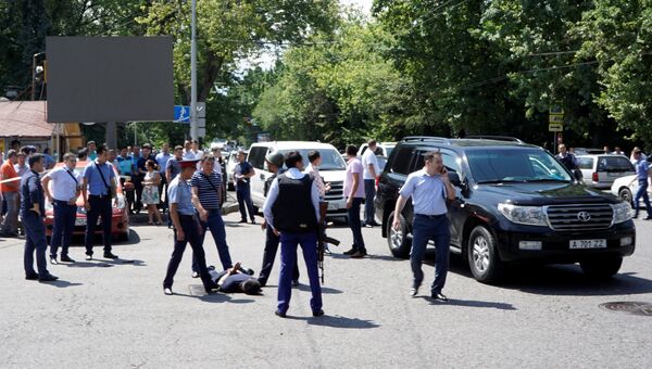 Сотрудники правоохранительных органов проводят задержание подозреваемого в стрельбе на улице Алма-Аты, Казахстан. 18 июля 2016