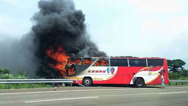 Полицейский и свидетель ДТП пытаются разбить окна горящего автобуса на Тайване