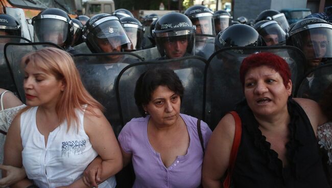 Горожане напротив группы полицейского спецназа на улице близ захваченного в Ереване здания полка патрульно-постовой службы