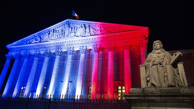 Здание Бурбонского дворца в Париже, где заседает нижняя палата парламента Франции – Национальная ассамблея, подсвеченное в цвета французского флага в связи с терактом в Ницце 14 июля 2016 года. Депутаты Национальной ассамблеи 19 июля 2016 года приняли законопроект о продлении применения закона № 55-385 от 3 апреля 1955 года в отношении чрезвычайного положения на шесть месяцев