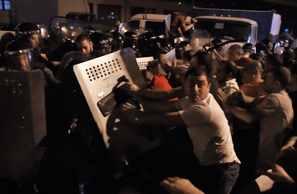 Протестующие во время столкновения с полицейскими на улице близ захваченного в Ереване здания полка патрульно-постовой службы
