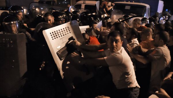Протестующие во время столкновения с полицейскими на улице близ захваченного в Ереване здания полка патрульно-постовой службы