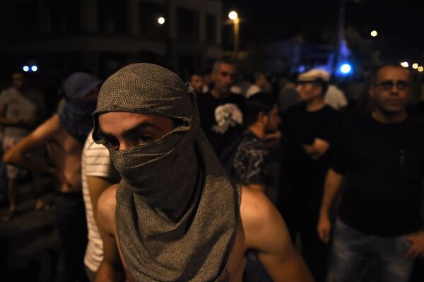 Протестующие во время столкновения с полицейскими на улице близ захваченного в Ереване здания полка патрульно-постовой службы. 21 июля 2016