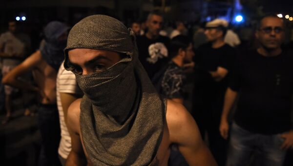 Протестующие во время столкновения с полицейскими на улице близ захваченного в Ереване здания полка патрульно-постовой службы. 21 июля 2016