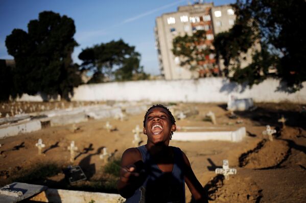 Бразильский мальчик играет с воздушным змеем на кладбище в фавелах Рио-де-Жанейро