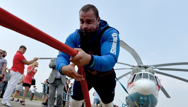 Белорусский силач Кирилл Шимко, рекордсмен книги Гиннеса, устанавливает новый рекорд - сдвигает вертолет Ми-26 весом более 30 тонн