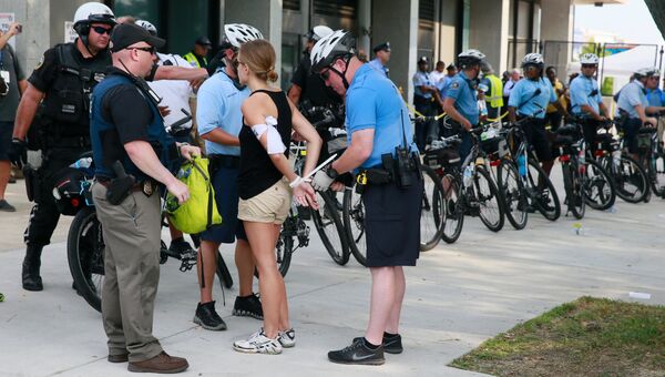 Полицейские задерживают одну из участниц акции в поддержку кандидата в президенты США от Демократической партии Бернарда Сандерса в Филадельфии