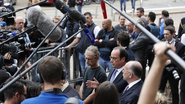 Президент Франции Франсуа Олланд, мэр Сент-Этьен-дю-Рувр и министр внутренних дел Франции Бернар Казнев общаются с прессой у входа в мэрию города. Франция, 26 июля 2016
