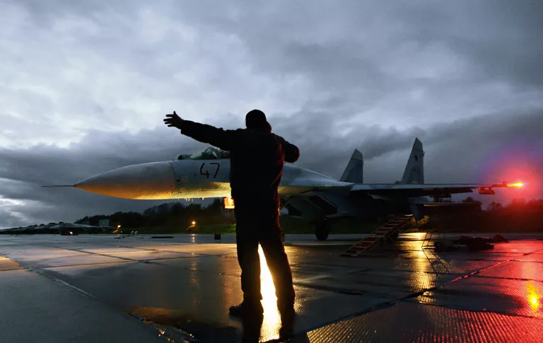 Военный техник дает отмашку на взлет истребителя Су-27 Военный техник дает отмашку на взлет истребителя Су-27