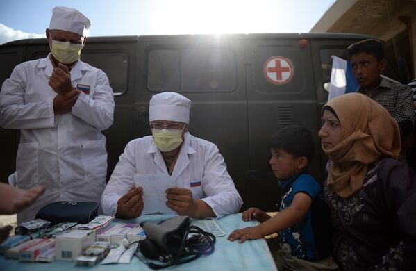 Российские врачи консультируют жителей населенного пункта Каукаб в Сирии во время раздачи российской гуманитарной помощи
