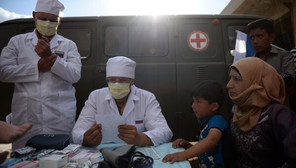Российские врачи консультируют жителей населенного пункта Каукаб в Сирии во время раздачи российской гуманитарной помощи. Архивное фото
