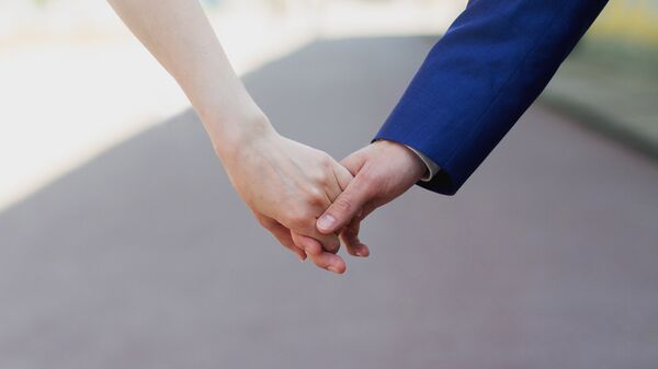 Мужчина и женщина держатся за руки. Архивное фото