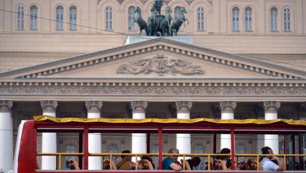 Туристы проезжают на экскурсионном автобусе мимо Большого театра в Москве. Архивное фото