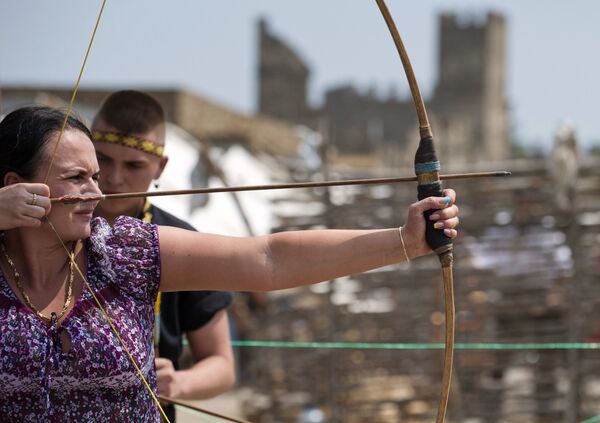 Посетительница Международного Рыцарского Фестиваля Генуэзский шлем стреляет из лука