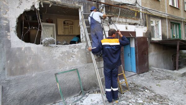 Сотрудники газовой службы восстанавливают поврежденное газоснабжение в пятиэтажном доме в Ясиноватой в Донбассе, пострадавшем в результате обстрела города со стороны украинских силовиков