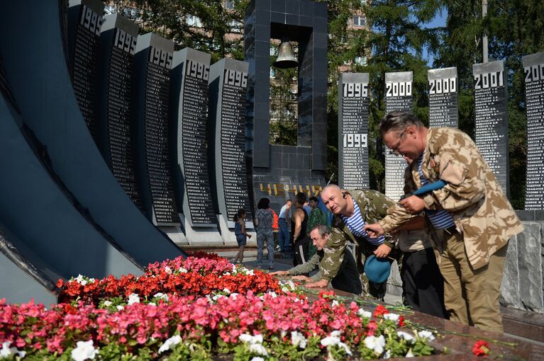 Мужчины возлагают цветы к мемориалу Черный тюльпан во время празднования дня ВДВ в Екатеринбурге