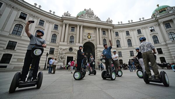 Туристы катаются на сигвее у императорской резиденции Хофбург в Вене
