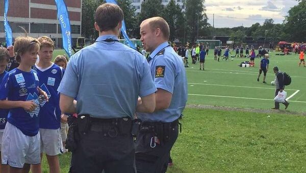 Полицейские разговаривают с игроками юниорской команды Херд на детском футбольном турнире Norway Cup