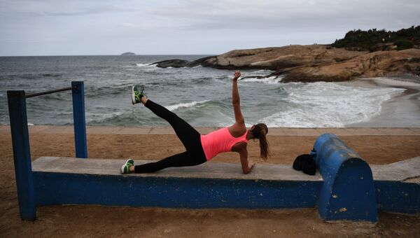 Девушка занимается спортом на пляже Ипанема в Рио-де-Жанейро