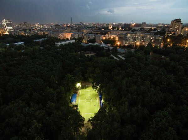 Люди играют в футбол в Нескучном саду в Москве
