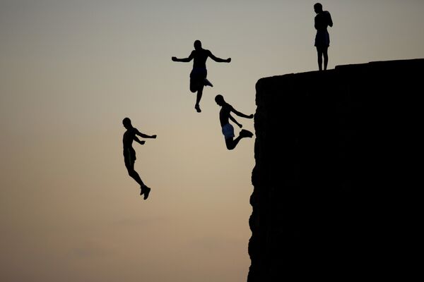 Дети прыгают в Средиземное море с древних стен Акко, Израиль