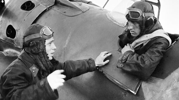 Летчик-истребитель, Герой Советского Союза, младший лейтенант Виктор Васильевич Талалихин беседует со своим боевым товарищем, сидящим в кабине самолета. Август 1941 года
