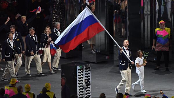 Знаменосец сборной России Сергей Тетюхин несет российский флаг на церемонии открытия летних Олимпийских игр в Рио