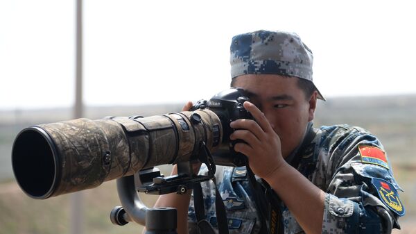 Военнослужащий армии Китая фотографирует во время международного конкурса