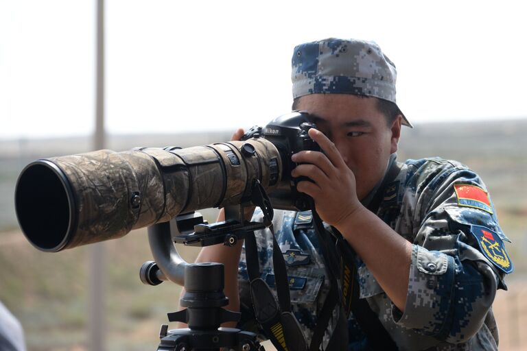 Военнослужащий армии Китая фотографирует во время международного конкурса Ключи от неба