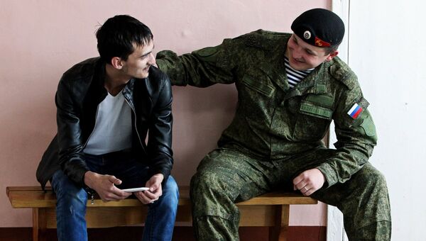 Морской пехотинец общается с призывником на сборном призывном пункте во Владивостоке. Архивное фото
