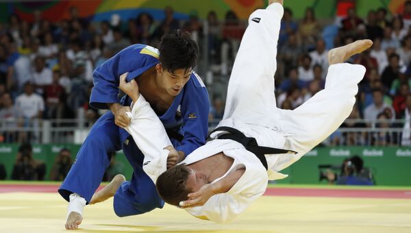 Дзюдоисты Сёхэй Оно (Япония) и Дирк ван Тихелт (Бельгия) во время поединка в весовой категории до 73 кг на Олимпийских играх в Рио-де-Жанейро