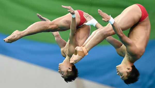 Чэнь Айсень и Линь Юэ (КНР) во время финальных соревнований по синхронным прыжкам с вышки 10 м среди мужчин на XXXI летних Олимпийских играх